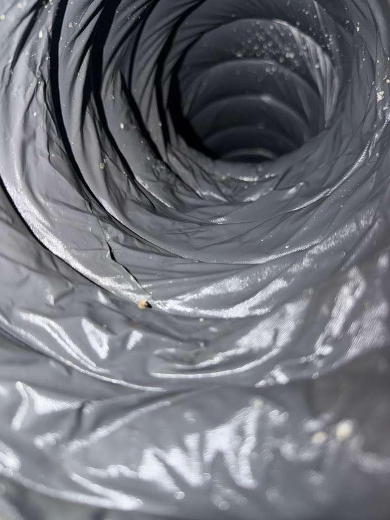 El mismo tipo de ducto de metal en espiral después de la limpieza, con el revestimiento visiblemente libre del polvo de antes